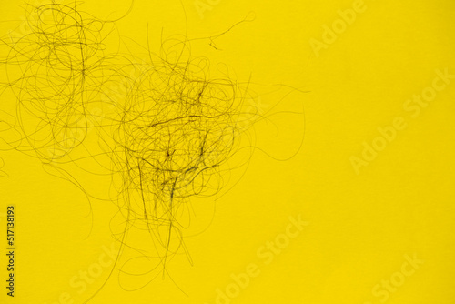 Fototapeta Naklejka Na Ścianę i Meble -  Fallen hair on the yellow background. Baldness and hair loss problem