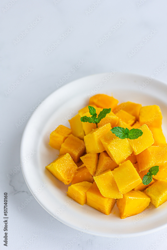 Fresh and Ripe Mango Cubes in a Plate on White Background Vertical Photo