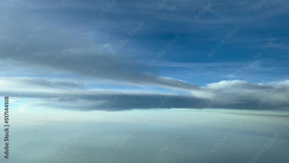 Typical summer sky from a jet cockpit at 12000 metres with some clouds and hazy. SE Spain during an extreme hotwave. Pilot point of view. 4K 60FPS.