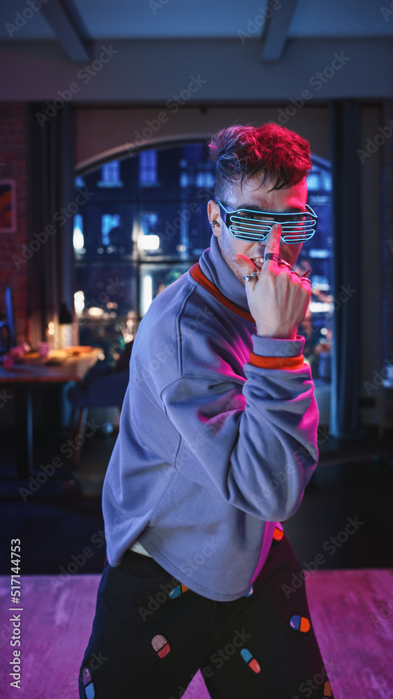 Vertical Screen: Portrait of a Handsome Young Man Dancing in Stylish Futuristic Neon Glowing Glasses, Having a Party at Home in Loft Apartment. Recording Videos for Social Media Mobile App.