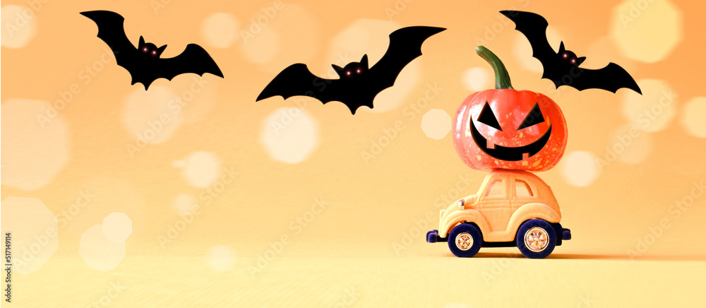 Toy car with funny pumpkin on the roof and bats on orange background. Space for text. Halloween background