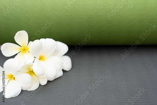 green yoga mat and a flower outdoor, healthy and sport concept © tatomm