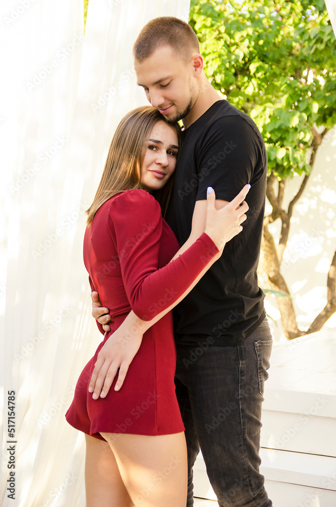 Naklejka premium beautiful sexy young couple standing in tropical garden near pool and hugging