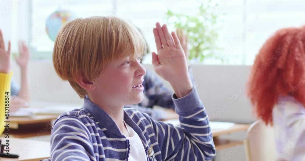 custom made wallpaper toronto digitalCute boy in casual wear raising hand and answering teacher's question during lesson at school. Smart preteen male pupil wanting to get good grades.