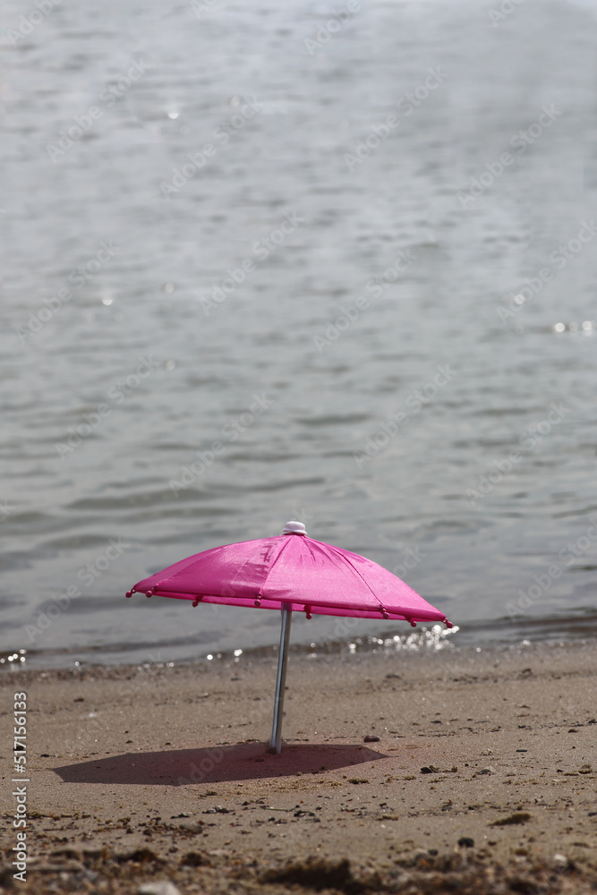 beach umbrella in sand on a beach near water beach umbrella in sand on a beach near water