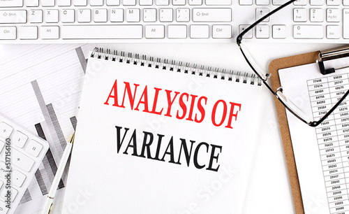 Fotografie Text ANALYSIS OF VARIANCE on Office desk table with keyboard, notepad and analysis chart on white background