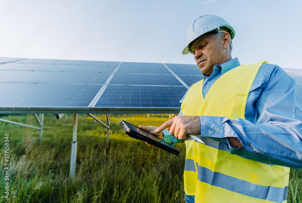 Solar engineer working with digital tablet at renewable energy farm. Alternative Eco energy concept Solar engineer working with digital tablet at renewable energy farm. Alternative Eco energy concept