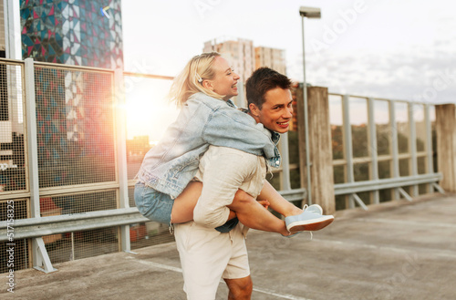summer holidays, love and people concept - happy young couple having fun on roof top parking