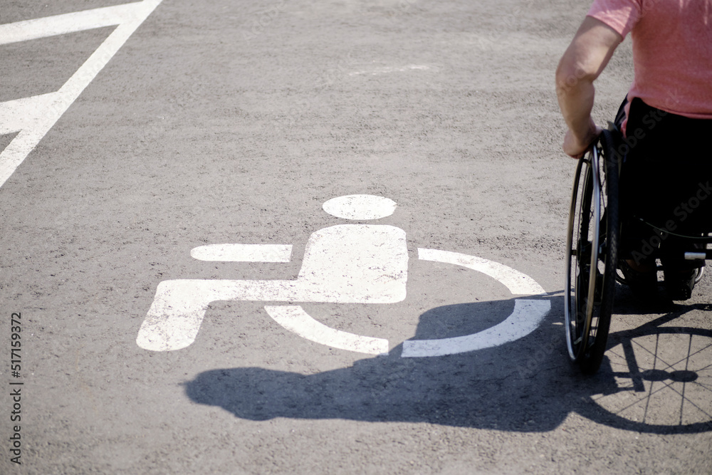 Obraz premium A person with disability Image, symbol of a person using a wheelchair in a public transport parking lot, copy space