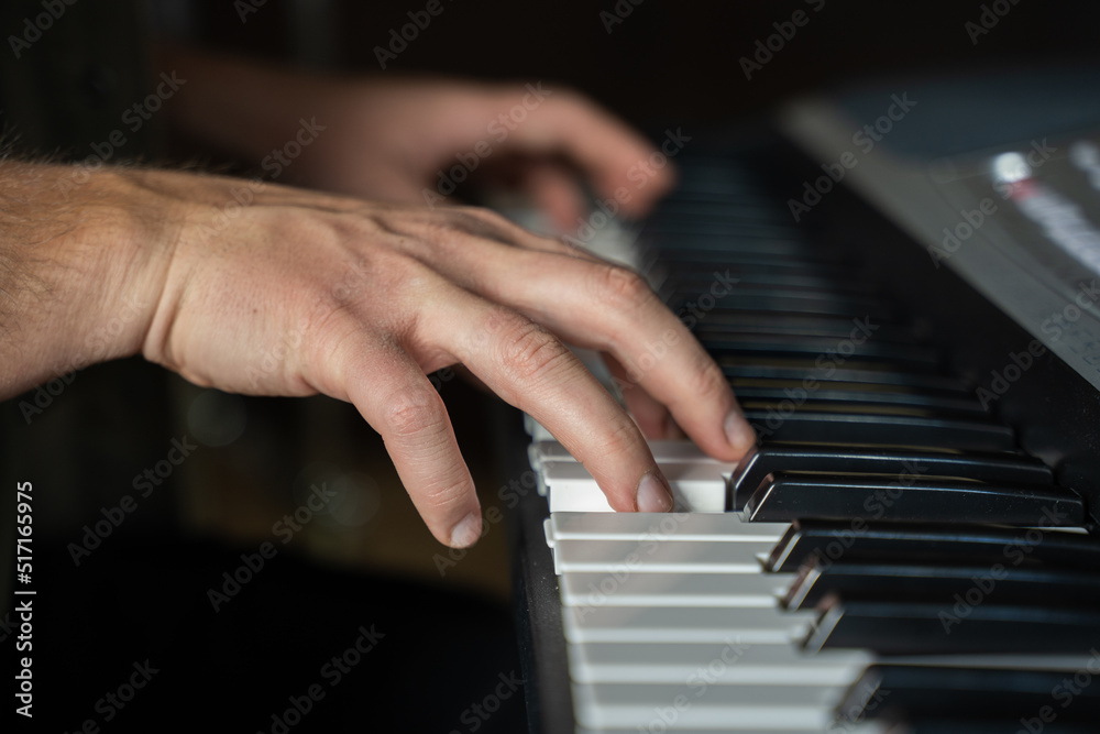 Man hands practice playing synthesizer and improvises upbeat melody. Pianist plays musical instrument keyboard in music studio extreme closeup