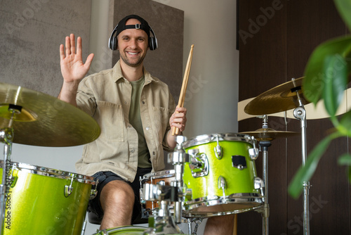 Tableau sur toile Young man records drum lesson on electronic device in equipped music studio