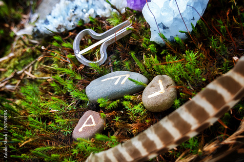 Rune stones on a moss. Different types of crystals on the forest floor. Future reading, life balance or esoteric and wiccan concept. 
