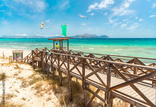 Platja de Muro, Majorka. Wooden platform and lifeguard tower on the sandy sea beach photo