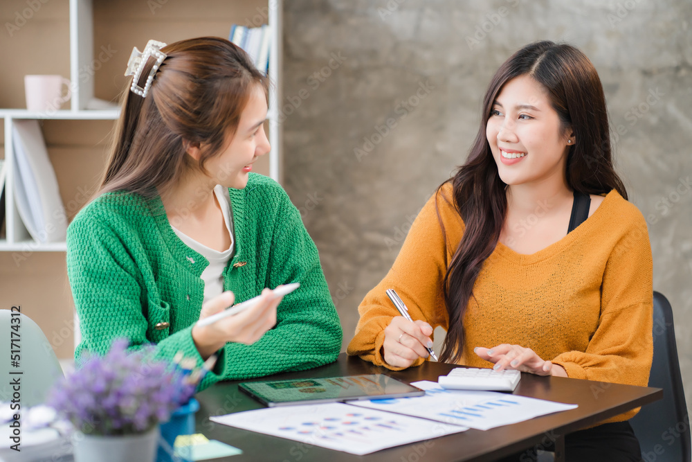Two beautiful young asian businesswoman working together using digital tablet at office