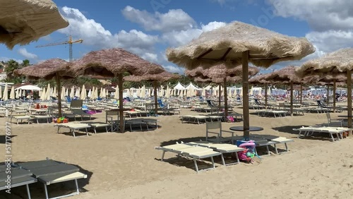 Windy beach umbrellas under a sunny and cloudy sky