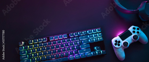 Top down view of colorful illuminated gaming accessories laying on table. Professional computer game playing, esports business and online world concept photo