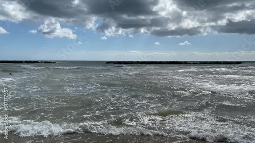 Windy Beach and sea waves under a cloudy summer sky