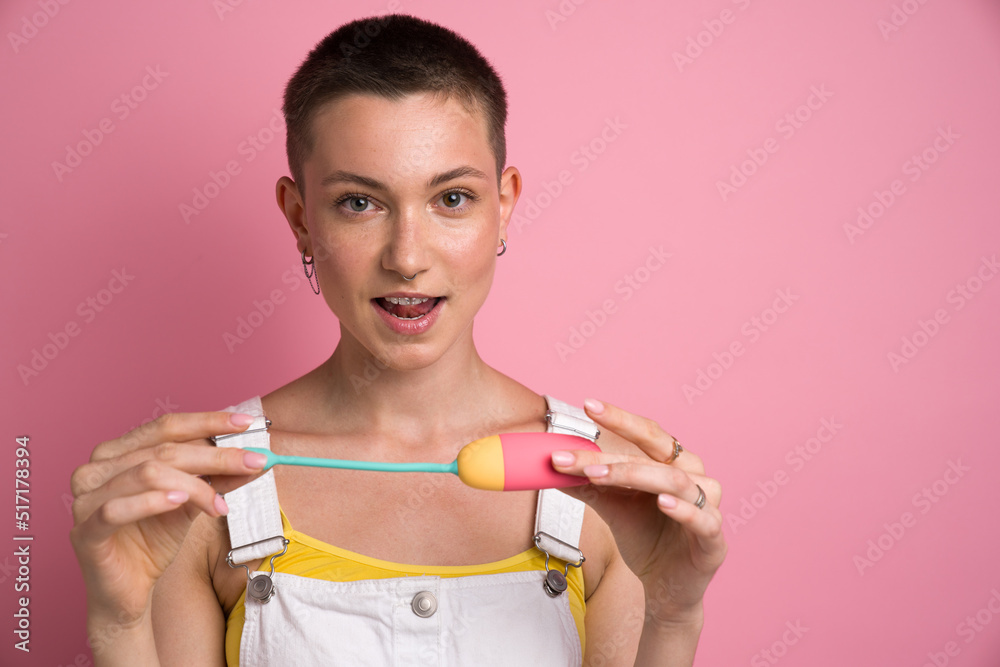 Woman holding Kegel trainer and looking with open mouth at the camera Woman holding Kegel trainer and looking with open mouth at the camera