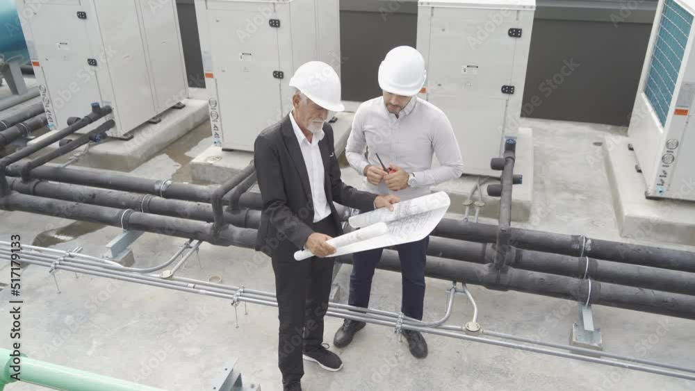 Engineer men or worker team, people working in industry factory. Chiller tower on rooftop building. System work machine. Condenser Water Supply pipe lines. Ventilation compressor Engineer men or worker team, people working in industry factory. Chiller tower on rooftop building. System work machine. Condenser Water Supply pipe lines. Ventilation compressor