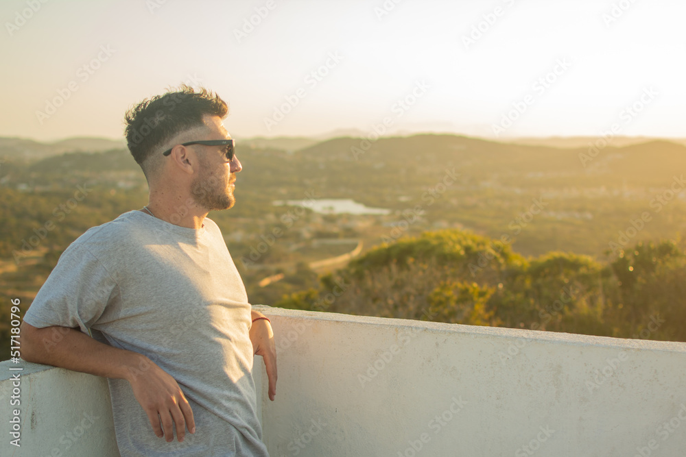 person looking at cityscape during sunset in buzios, from the lookout point in brava, brazil. horizontal