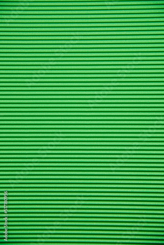 Abstract background made of corrugated paper for green application. Space for text. Texture. Horizontal stripes.