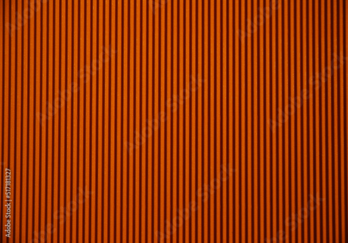 Abstract background made of corrugated paper for orange application. Space for text. Texture. Vertical stripes.