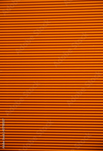 Abstract background made of corrugated paper for orange application. Space for text. Texture. Horizontal stripes.