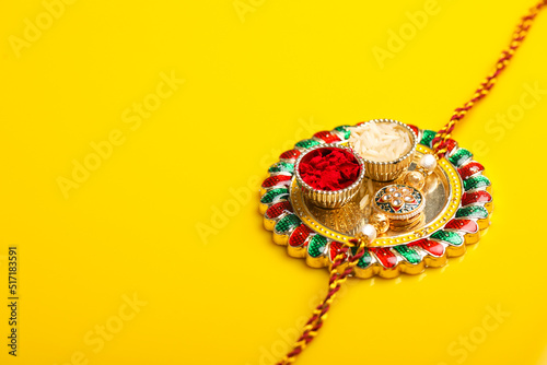 Tablou pe pânză Indian festival raksha bandhan: puja thali and rakhi or wrist band on yellow background