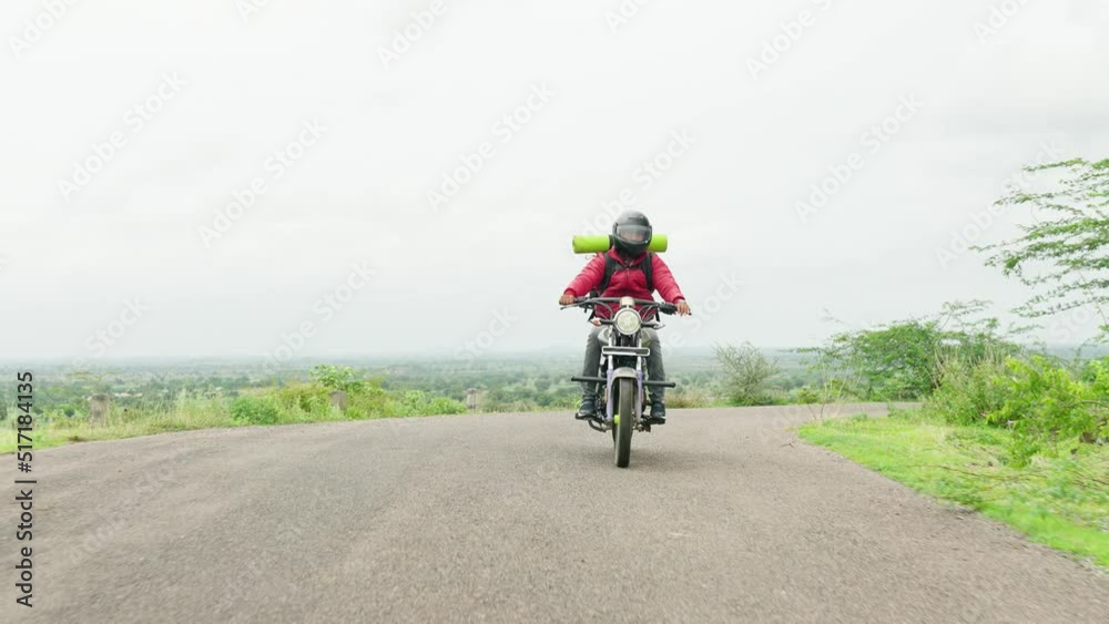 Forward tracking shot of motorbke Rider with backpack traveling on motorbike near mountains on road - concept of freedom, weekend holidays and outdoor activities Forward tracking shot of motorbke Rider with backpack traveling on motorbike near mountains on road - concept of freedom, weekend holidays and outdoor activities