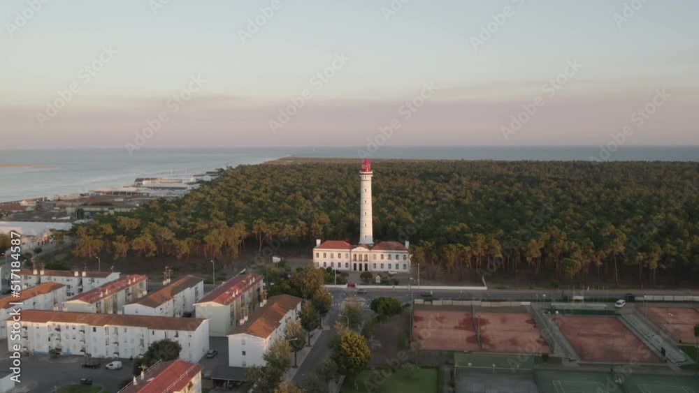 Vila Real de Santo António Lighthouse against lush coastal forest. Ocean on the horizon. Aerial pedestal shot Vila Real de Santo António Lighthouse against lush coastal forest. Ocean on the horizon. Aerial pedestal shot