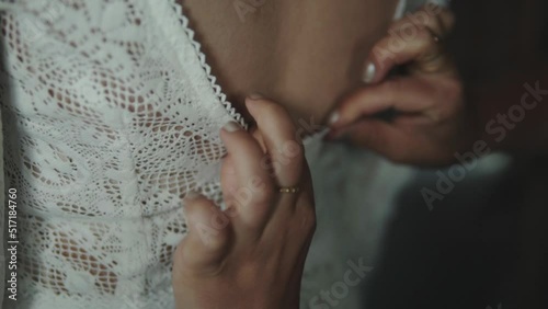 Zipping and adjusting wedding dress in slow motion photo