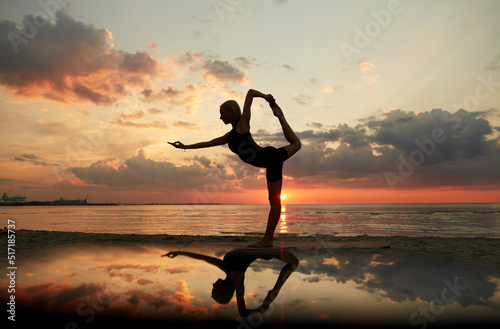 fitness  sport  and healthy lifestyle concept - woman doing yoga dancer pose on beach over sunset