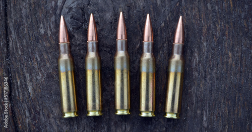 Rifle cartridges on a wood background. Top view