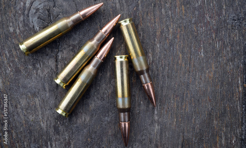 Rifle cartridges on a wood background. Top view