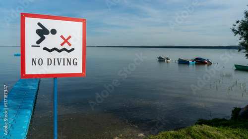 No Diving sign at beach, lake Naroch, Belarus. Warning sign of shallow water. Warning notice sign do not jump in water. photo