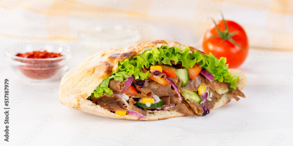 Döner Kebab Doner Kebap fast food in flatbread on a wooden board panorama