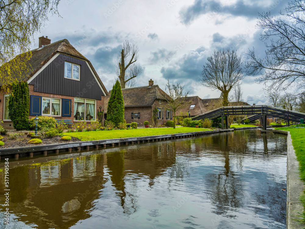 Beautiful gardens, Dutch houses and bridges over the canal in the Charming village of Giethoorn, Netherlands