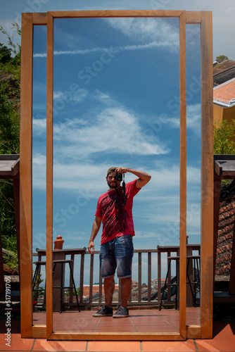 Fotógrafo joven tomándose una fotografía a si mismo a través de un espejo en el tejado photo