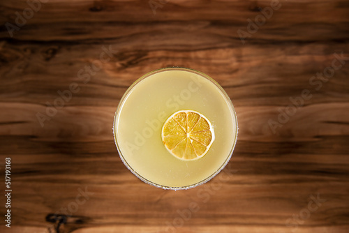 cocktail decorated with a slice of lime desidratada in a zenith plane on an old wood base photo