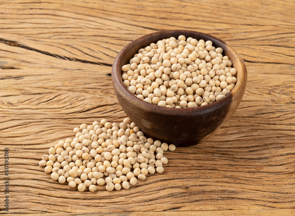 Uncooked soy beans in a bowl over wooden table Uncooked soy beans in a bowl over wooden table
