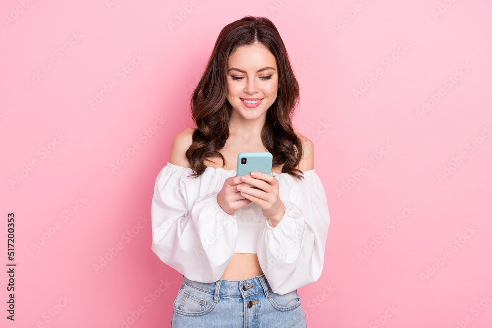 Photo of young stunning good mood blogger girl chatting with friends in smartphone isolated on pink color background Photo of young stunning good mood blogger girl chatting with friends in smartphone isolated on pink color background