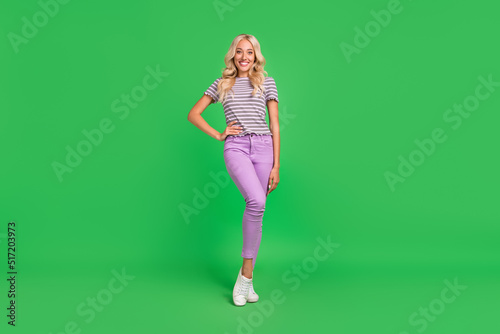 Full length portrait of satisfied stunning lady put hand waist posing isolated on green color background