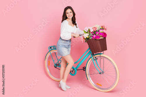 Full length portrait of pretty cheerful lady ride bike enjoy weekend vacation isolated on pink color background © deagreez