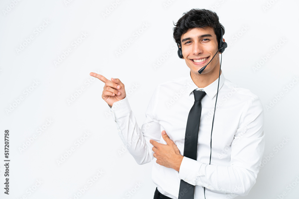 Telemarketer man working with a headset isolated on white background pointing finger to the side Telemarketer man working with a headset isolated on white background pointing finger to the side