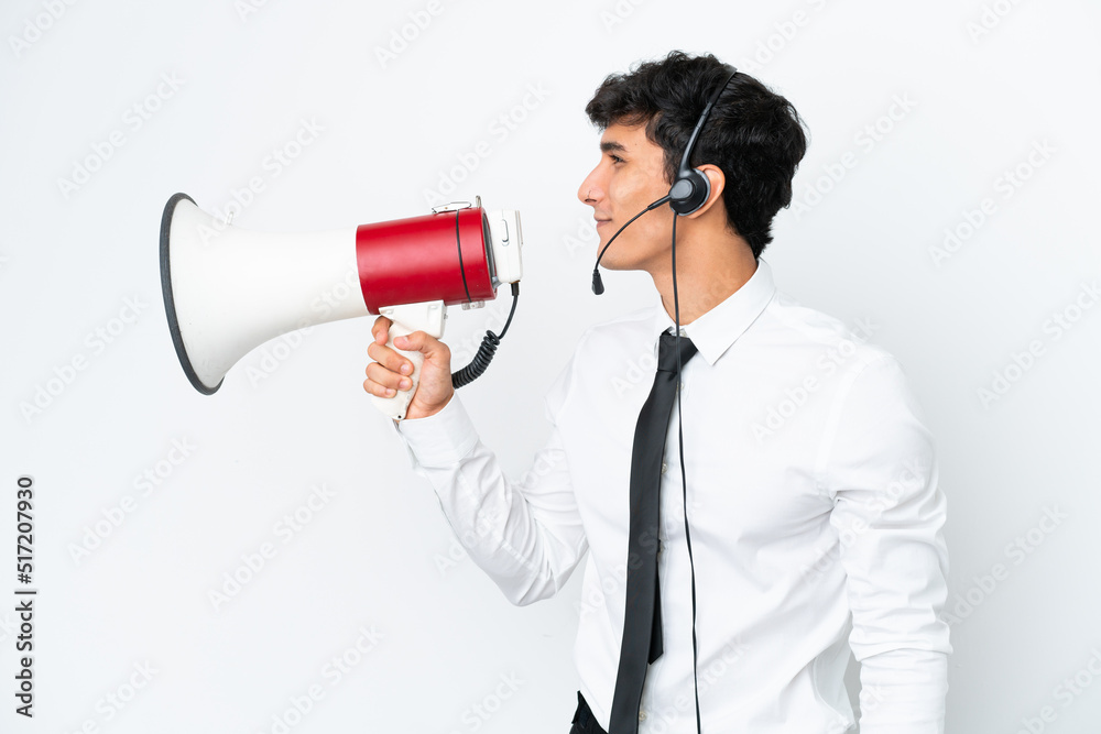 Telemarketer man working with a headset isolated on white background shouting through a megaphone Telemarketer man working with a headset isolated on white background shouting through a megaphone