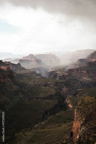 Fotografia Vertical majestic view of green canyon landscape disappearing in the fog