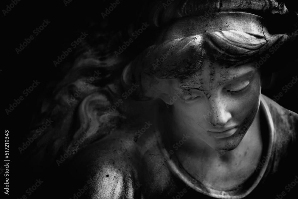 Fragment of an ancient statue of guardian angel. Black and white image.