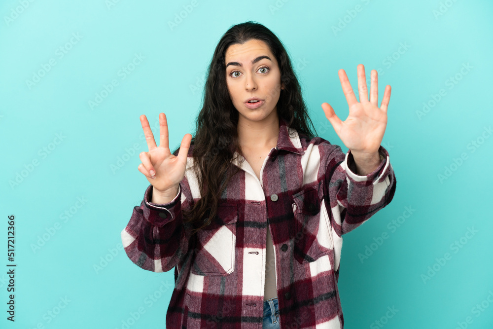 Young caucasian woman isolated on blue background counting eight with fingers