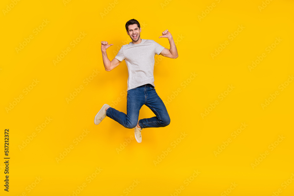 Full length body size view of attractive cheerful guy jumping demonstrating himself isolated over bright yellow color background