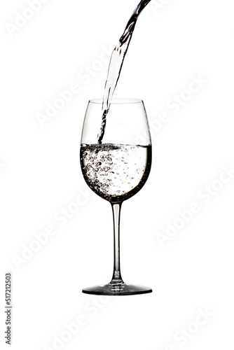 A splash of crystal clear water in a glass for wine. Water splashes. Drinking water. Alcohol. Isolated on white background